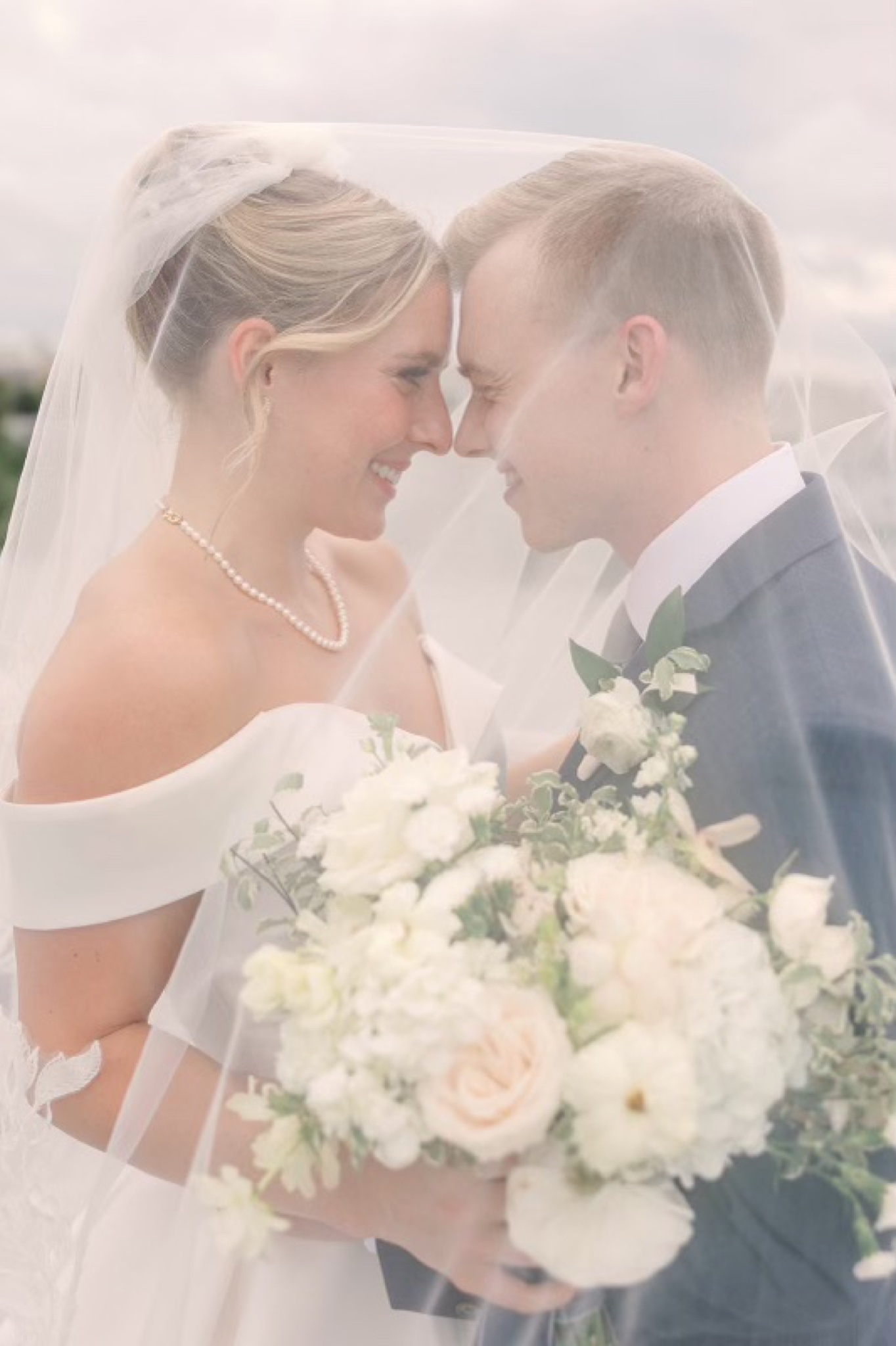 Bride and groom gazing at each other under the veil