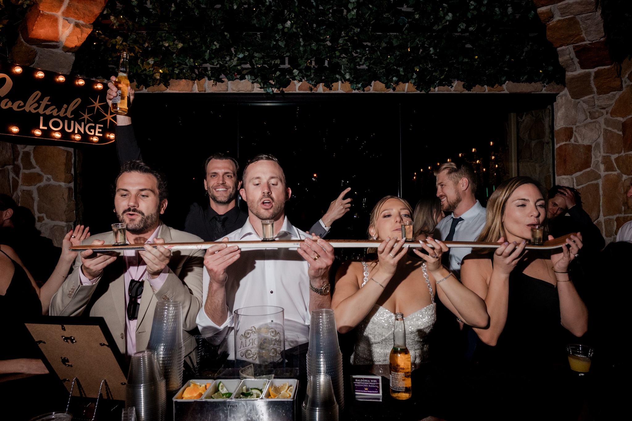 Bride, groom and friends doing a shot ski together