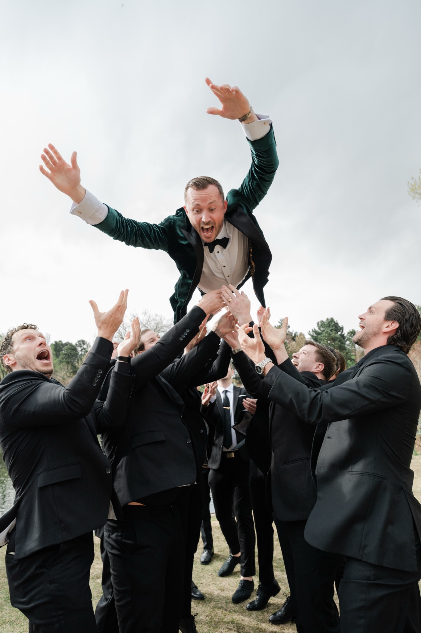 Groomsmen launching the groom into the air