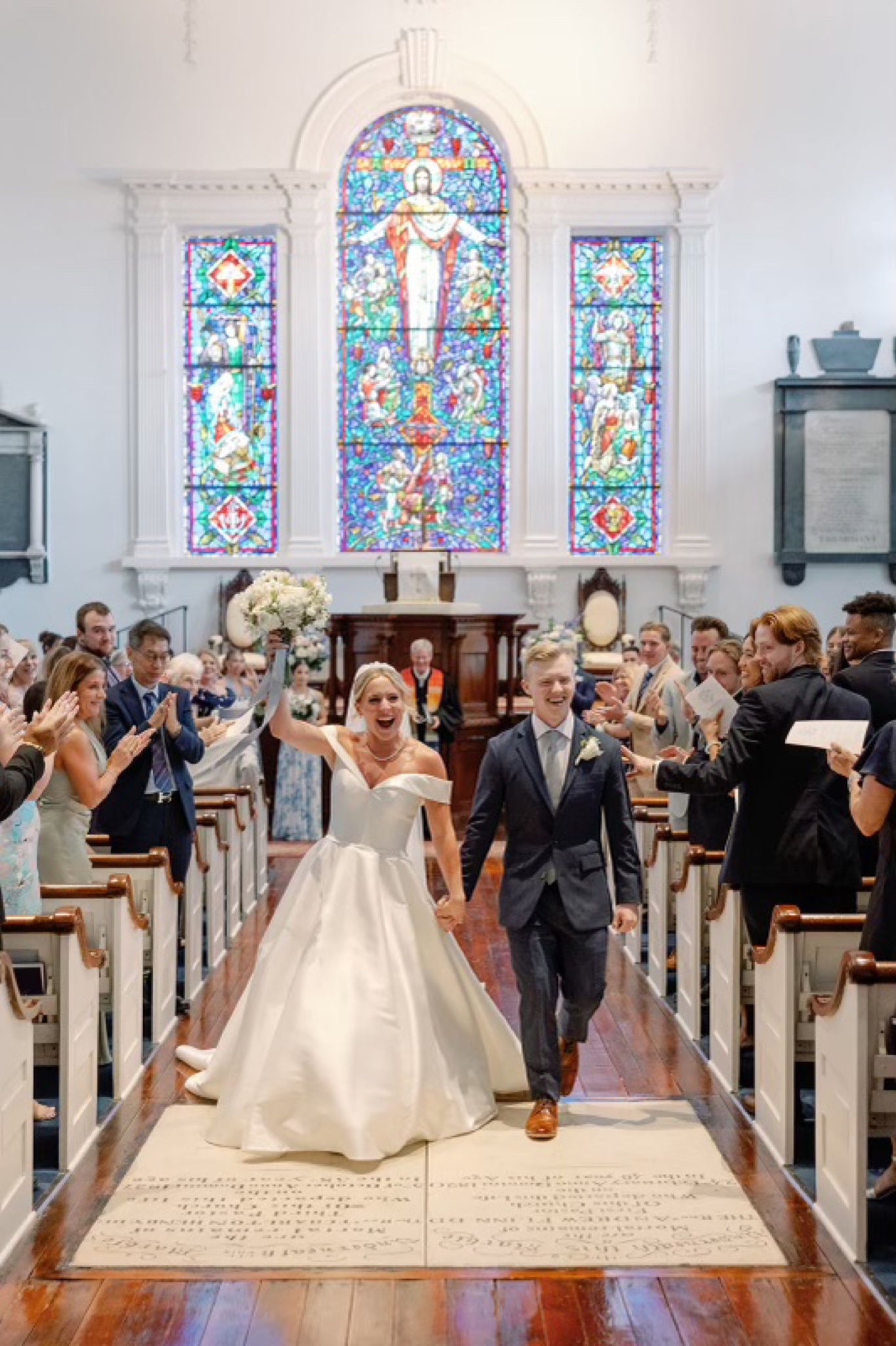 Couple cheering and laughing as they walk back down the aisle